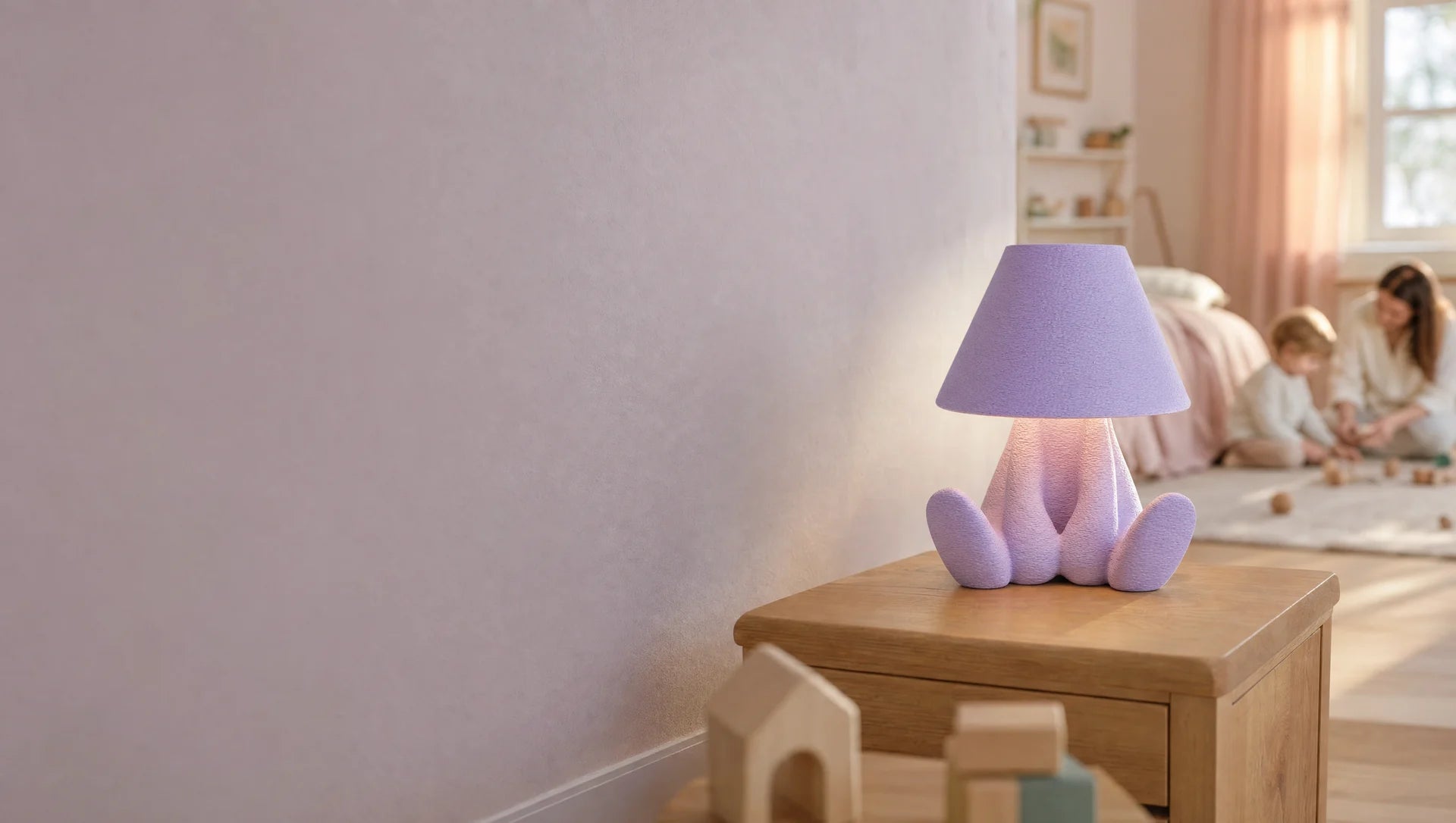 A lavender MIO lamp in a warm children's room, with a parent and child playing in the background